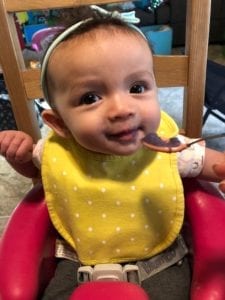6 month old Emmalee enjoying a puree of Okinawan sweet potato, ginger and coconut milk.