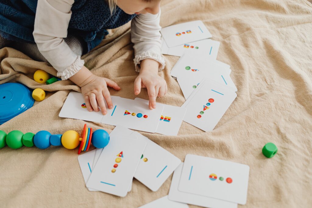 toddler playing with shape cards
