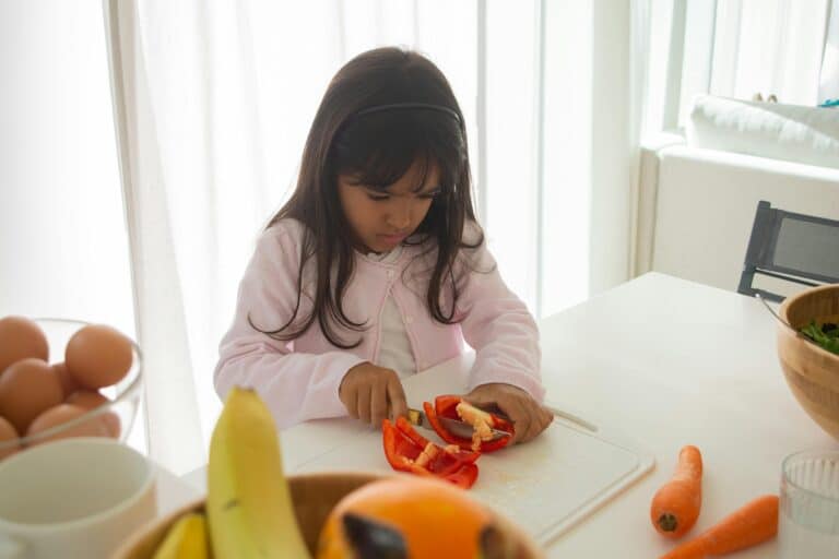 child cutting vegetables