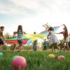 A group of kids playing together in the grass at the playground. Everyone is actively engaged in a fun game.