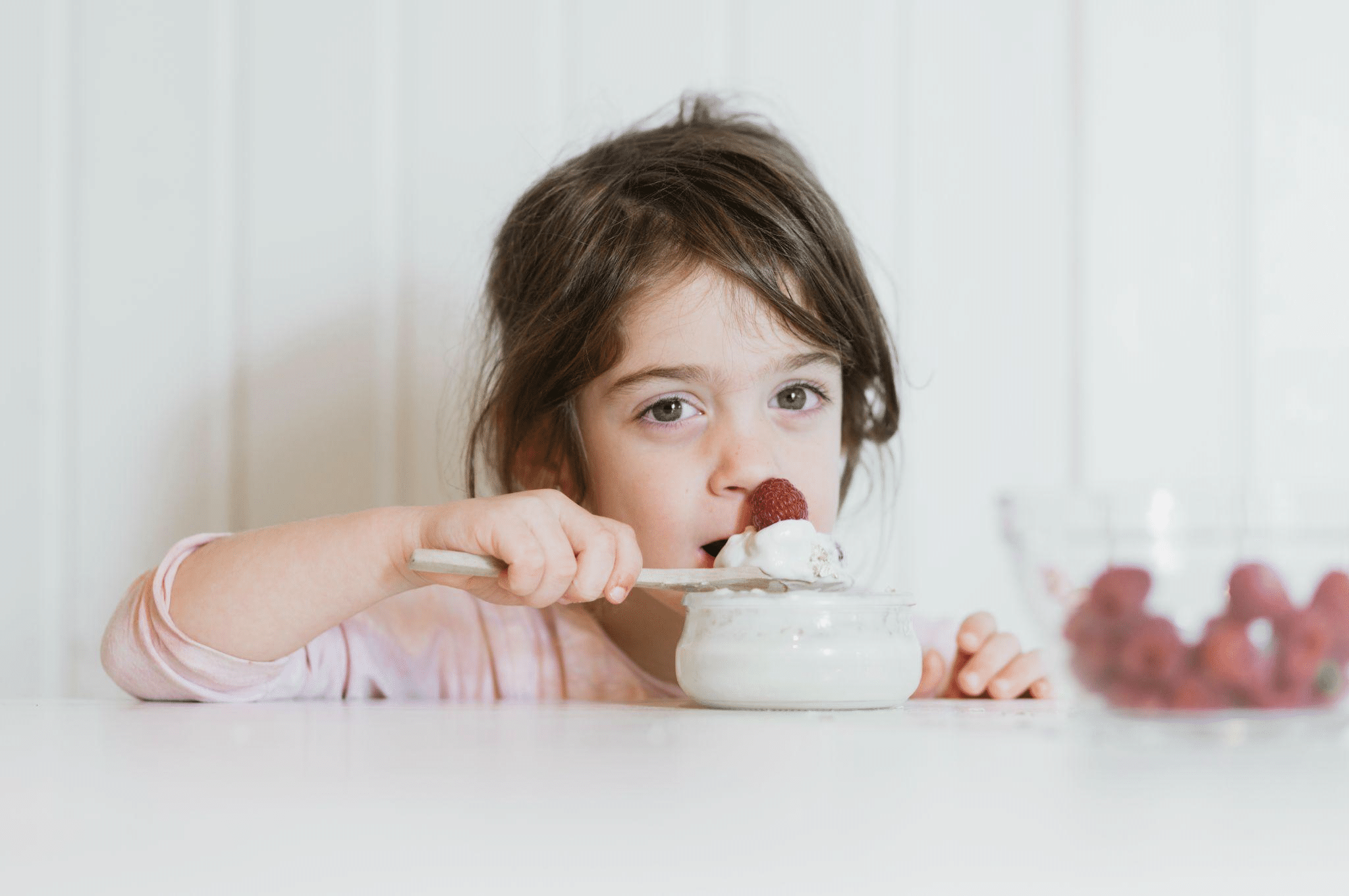 girl eating yogurt and berries
