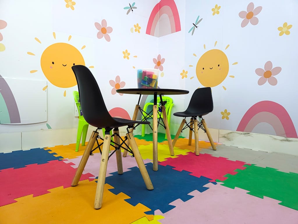Vibrant children's playroom featuring playful sun and rainbow wall art with colorful mats.