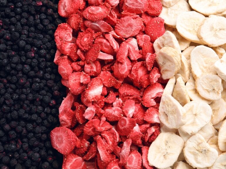 A close-up of an assembly of three piles of freeze-dried food, one of blueberries, one of strawberries, and one of bananas.