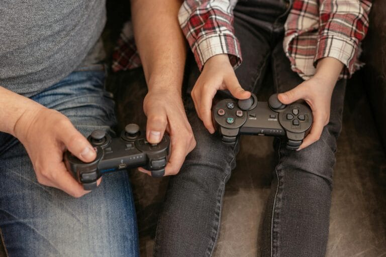 A parent and child bond over video games, sharing a fun and interactive moment with controllers.