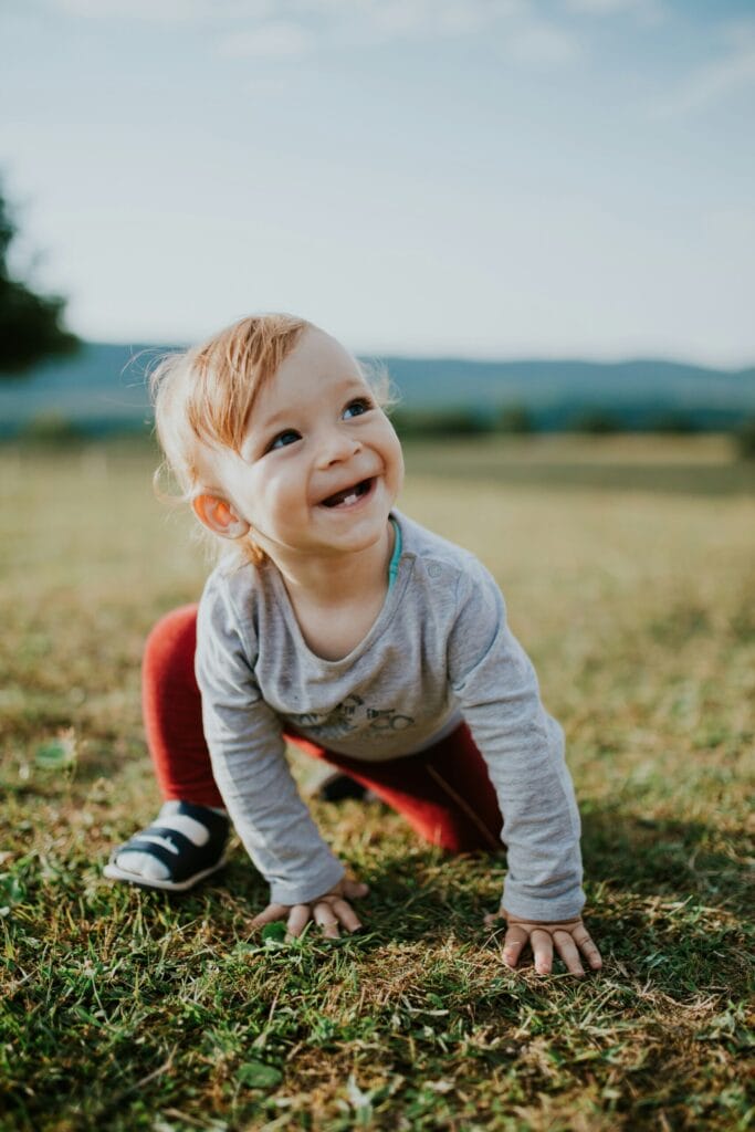 toddler sitting on grass