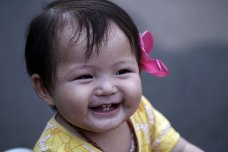 baby smiling with flower in her hair