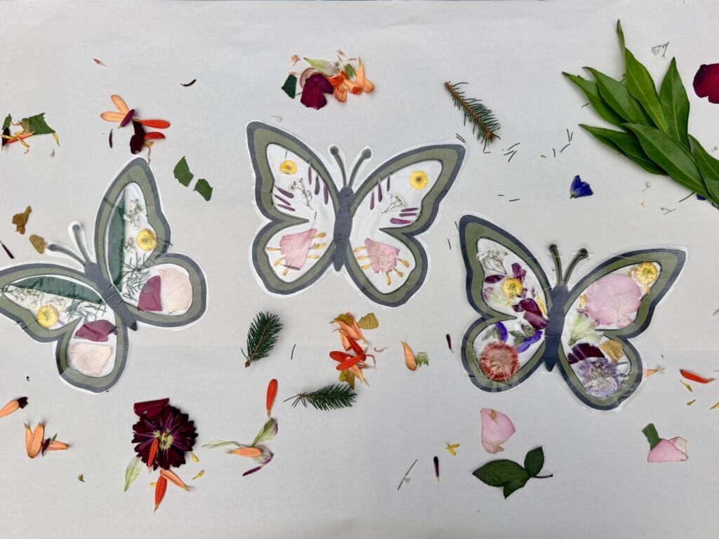 Pressed flower butterfly suncatchers on table