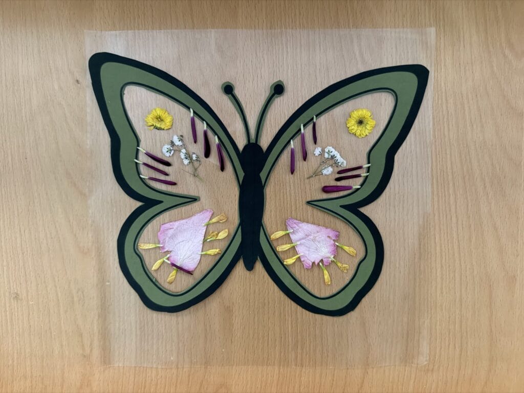 Pressed flower butterfly suncatchers on table
