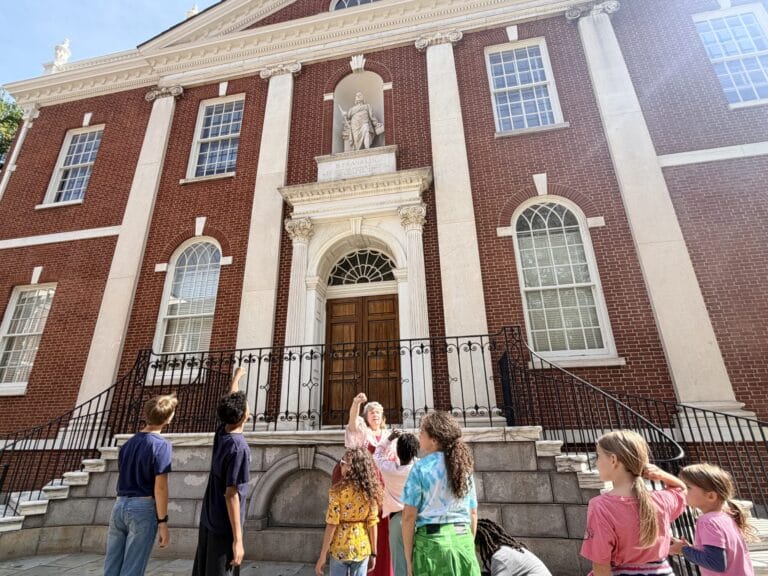Kids surrounding tour guide on Philly walking tour.