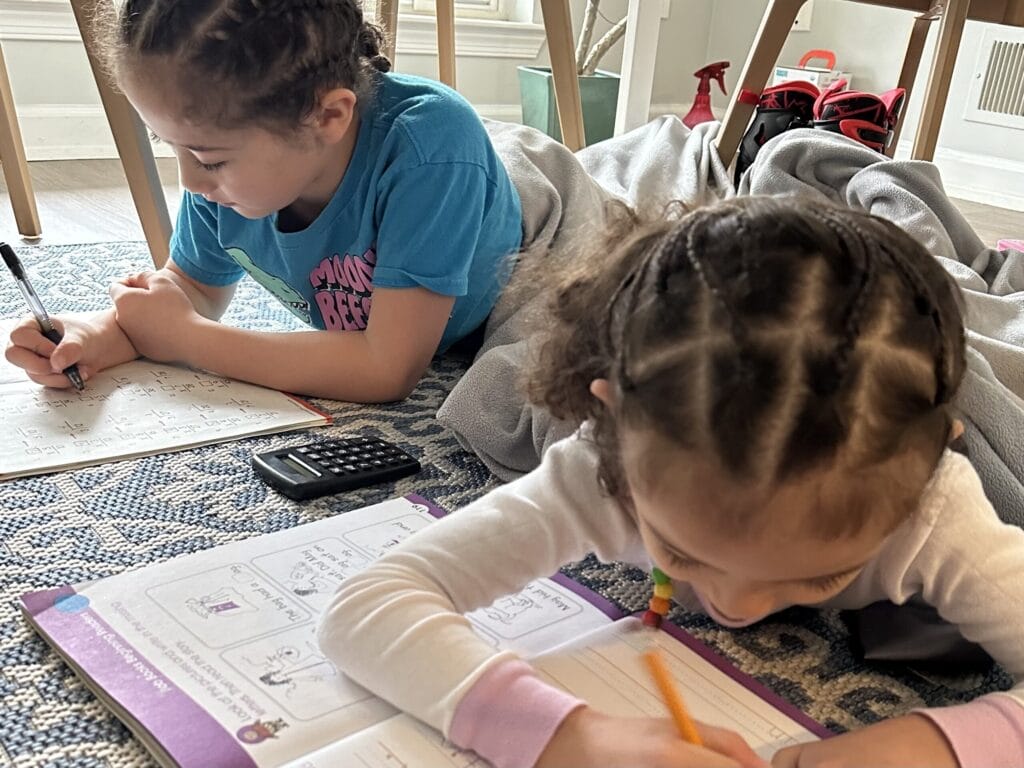 Homeschool kids doing their schoolwork under the table.