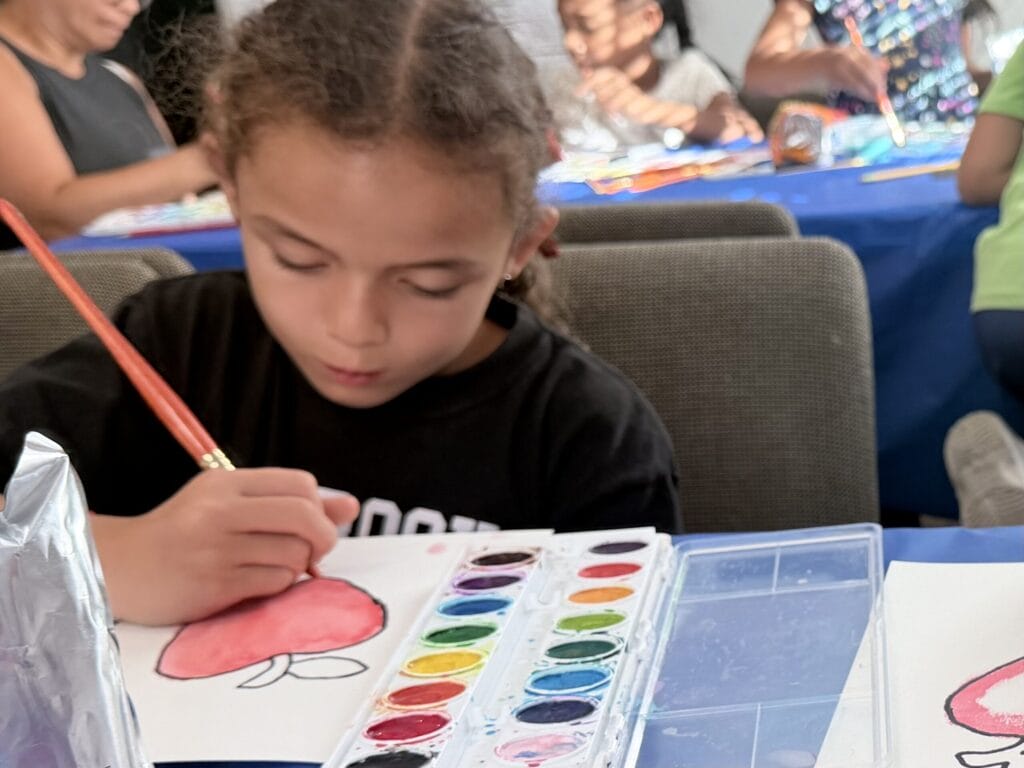 Girl painting with watercolors at the library.